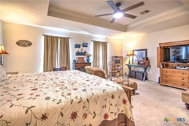 bedroom with crown molding, ceiling fan, a raised ceiling, and light carpet