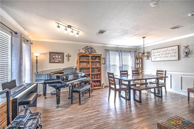 dining space featuring crown molding, dark wood-type flooring, and a textured ceiling