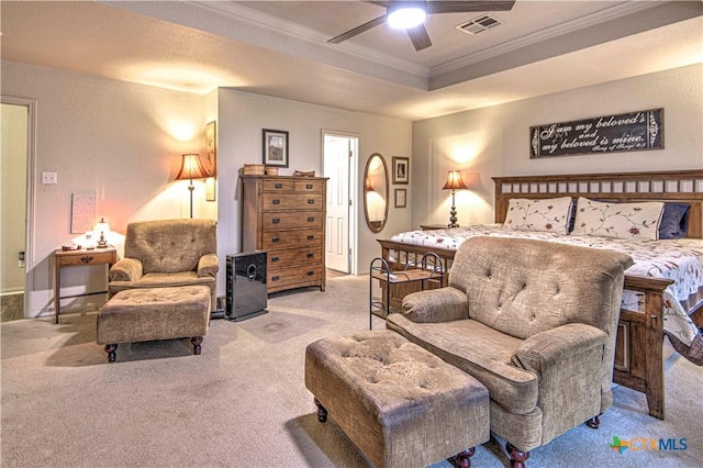 bedroom featuring ceiling fan, ornamental molding, a tray ceiling, and light carpet