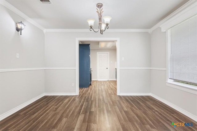 unfurnished dining area with baseboards, ornamental molding, wood finished floors, and an inviting chandelier