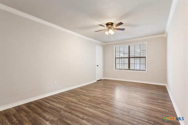 spare room featuring dark wood-style floors, baseboards, and crown molding