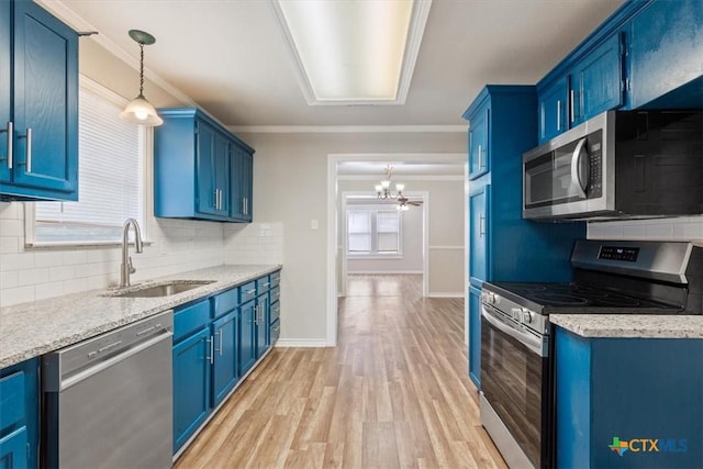 kitchen featuring light wood-style floors, appliances with stainless steel finishes, ornamental molding, blue cabinetry, and a sink