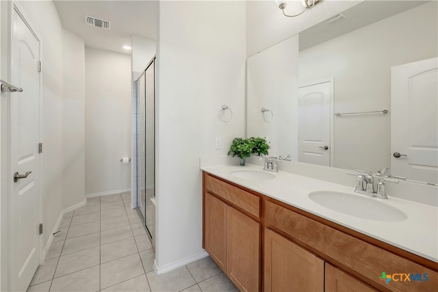 bathroom featuring an enclosed shower, vanity, and tile patterned floors