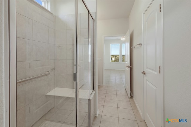 bathroom with tile patterned floors and a shower with door