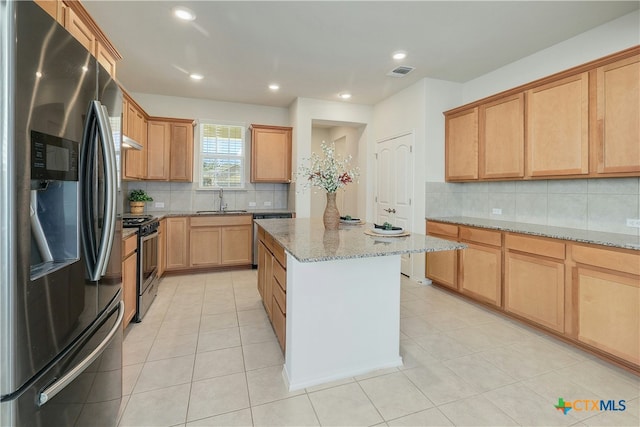 kitchen with light tile patterned flooring, sink, stainless steel appliances, light stone countertops, and decorative backsplash