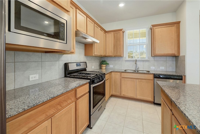 kitchen with stone counters, appliances with stainless steel finishes, sink, decorative backsplash, and light tile patterned floors