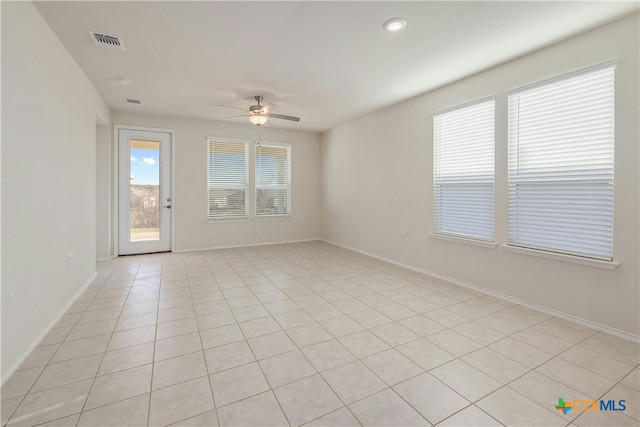 tiled empty room featuring ceiling fan