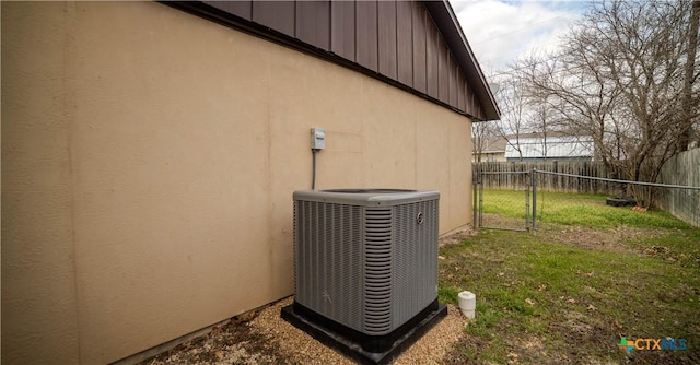 exterior details featuring stucco siding, fence, and central AC unit