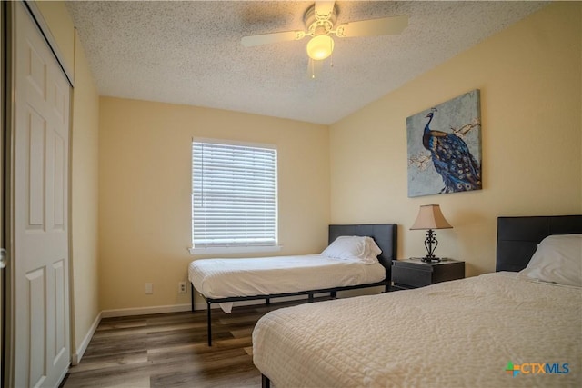 bedroom with baseboards, ceiling fan, wood finished floors, a textured ceiling, and a closet