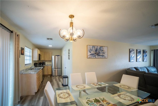 dining room featuring an inviting chandelier, visible vents, and dark wood-type flooring