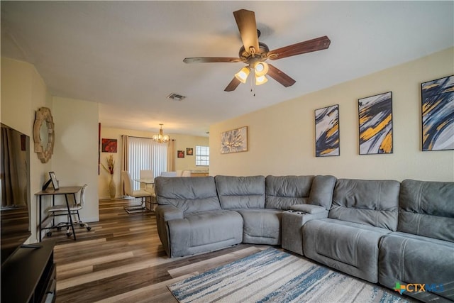 living room featuring ceiling fan with notable chandelier, wood finished floors, and visible vents