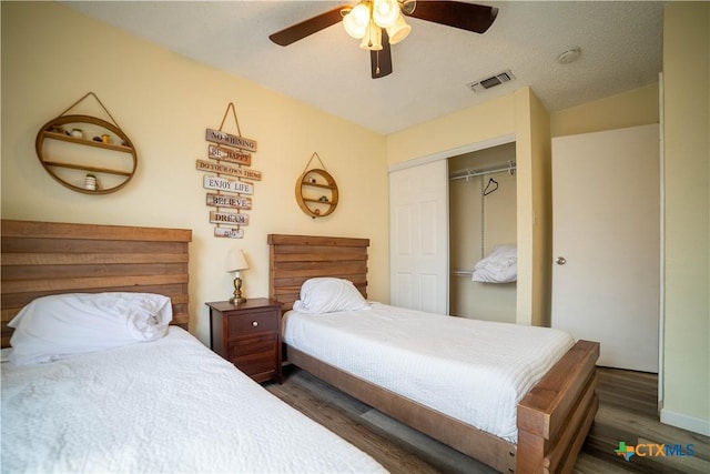 bedroom featuring lofted ceiling, a closet, visible vents, a ceiling fan, and wood finished floors