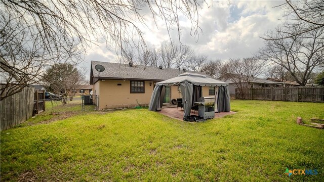 rear view of house with a patio, a fenced backyard, a gazebo, a yard, and a gate