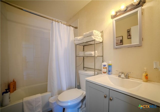 full bathroom with a textured wall, shower / bath combo, vanity, and toilet