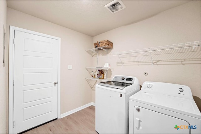 604 Cypress Arbor, Seguin, TX 78155 - laundry area featuring washer and clothes dryer, light wood-style floors, and baseboards