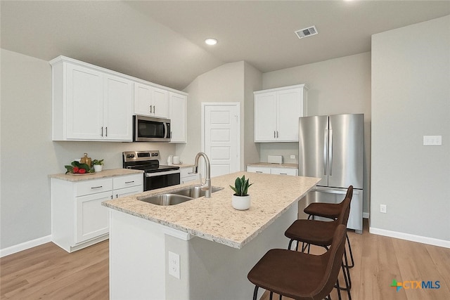 604 Cypress Arbor, Seguin, TX 78155 - kitchen with appliances with stainless steel finishes, a sink, baseboards, light wood-style flooring, and vaulted ceiling
