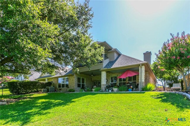 1320 Daisy Ln, Temple, TX 76502 - rear view of property with ceiling fan, brick siding, roof with shingles, and a chimney
