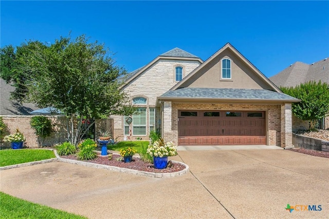 1320 Daisy Ln, Temple, TX 76502 - french country style house featuring an attached garage, brick siding, driveway, and stucco siding