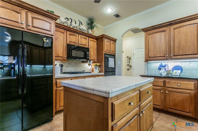 1320 Daisy Ln, Temple, TX 76502 - kitchen with black appliances, tile countertops, light tile patterned floors, ornamental molding, and decorative backsplash