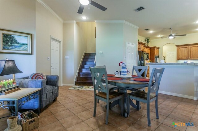 1320 Daisy Ln, Temple, TX 76502 - dining area with a ceiling fan, crown molding, light tile patterned floors, stairway, and arched walkways
