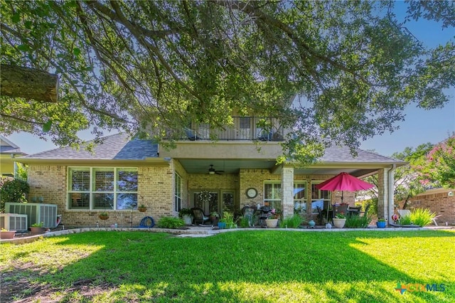 1320 Daisy Ln, Temple, TX 76502 - back of property with ceiling fan, brick siding, a lawn, and a patio area