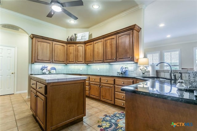 1320 Daisy Ln, Temple, TX 76502 - kitchen with tasteful backsplash, light tile patterned floors, brown cabinets, ornamental molding, and recessed lighting