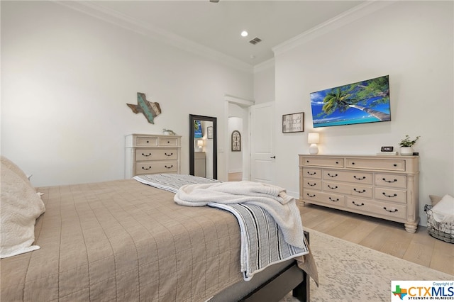 bedroom with ornamental molding and light wood-type flooring