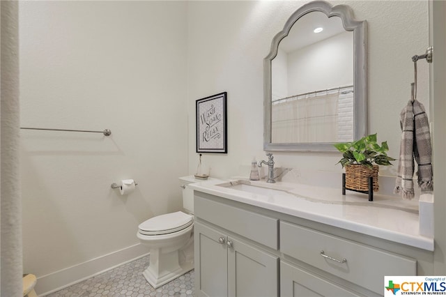 bathroom featuring tile patterned floors, vanity, and toilet