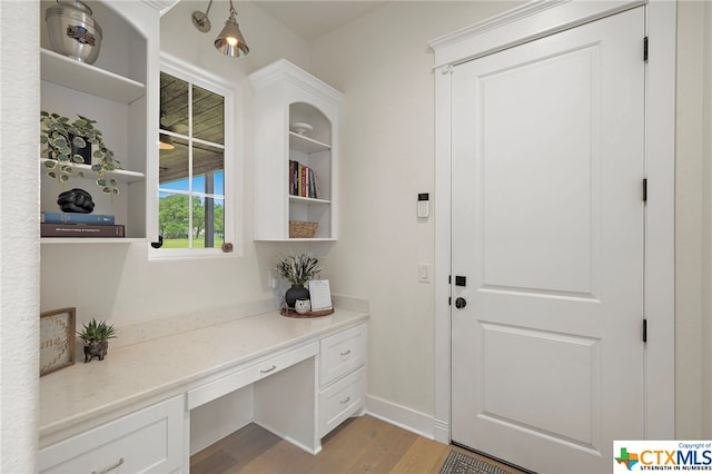 entryway with built in desk and light hardwood / wood-style floors