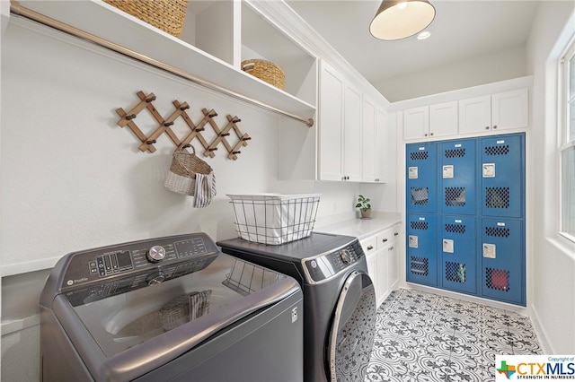 laundry room with cabinets, separate washer and dryer, and light tile patterned floors