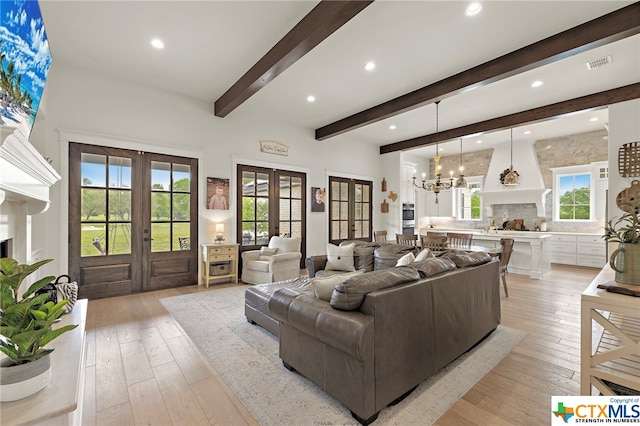 living room featuring french doors, a chandelier, light hardwood / wood-style floors, and beamed ceiling