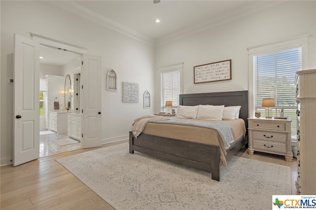 bedroom with multiple windows, ornamental molding, connected bathroom, and light wood-type flooring