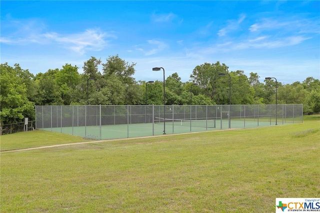 view of tennis court with a lawn