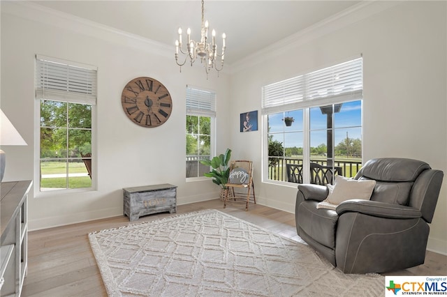 sitting room with a notable chandelier, crown molding, and light wood-type flooring