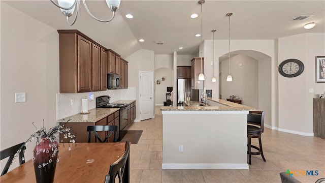 kitchen featuring arched walkways, visible vents, black appliances, light stone counters, and a sink