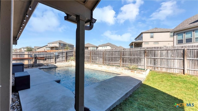 view of swimming pool with a fenced in pool, a residential view, a fenced backyard, and a lawn