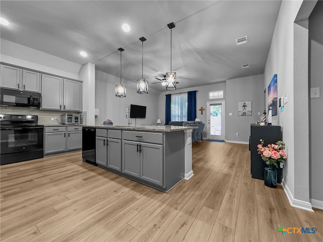 1525 Dryden Ave, Copperas Cove, TX 76522 - kitchen featuring black appliances, gray cabinets, open floor plan, a center island, and light wood-style floors