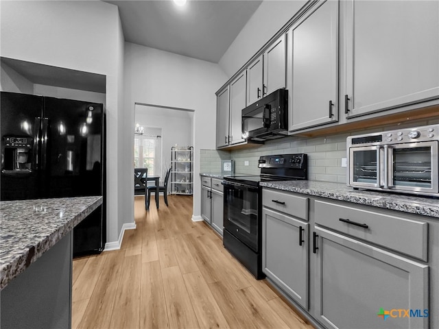 1525 Dryden Ave, Copperas Cove, TX 76522 - kitchen featuring black appliances, gray cabinetry, light wood finished floors, decorative backsplash, and light stone counters
