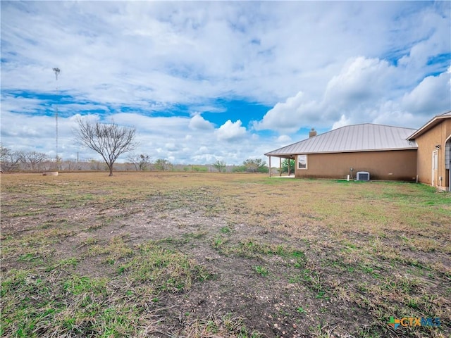 view of yard featuring a rural view and central AC unit