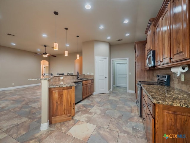 kitchen featuring stone countertops, ceiling fan, decorative light fixtures, kitchen peninsula, and stainless steel appliances