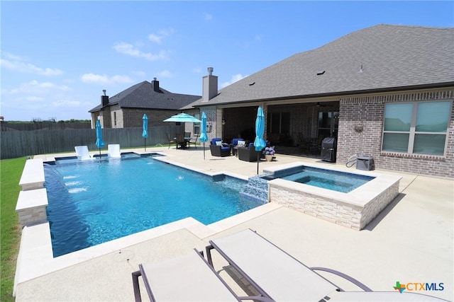 view of swimming pool featuring a patio area, a pool with connected hot tub, and fence