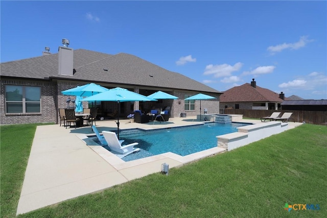 view of pool featuring a yard, a pool with connected hot tub, a patio, and fence