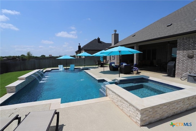 view of pool featuring a patio area, a fenced backyard, and a pool with connected hot tub