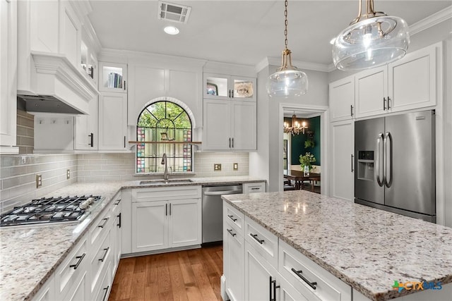 2717 Canyon Oaks Ct, Temple, TX 76502 - kitchen with stainless steel appliances, crown molding, light wood-type flooring, white cabinets, and backsplash