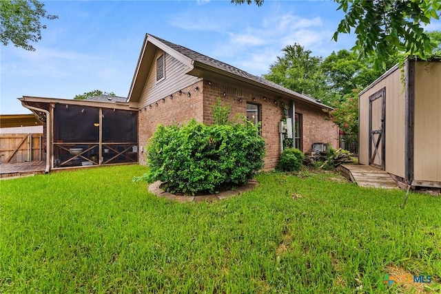 2717 Canyon Oaks Ct, Temple, TX 76502 - view of side of home with brick siding, a yard, a sunroom, and a storage unit
