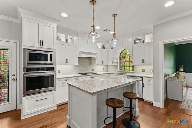 2717 Canyon Oaks Ct, Temple, TX 76502 - kitchen with appliances with stainless steel finishes, ornamental molding, white cabinetry, a center island, and recessed lighting