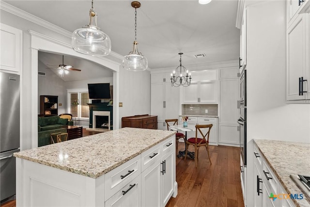 2717 Canyon Oaks Ct, Temple, TX 76502 - kitchen featuring stainless steel appliances, ceiling fan, decorative backsplash, a kitchen island, and dark wood finished floors