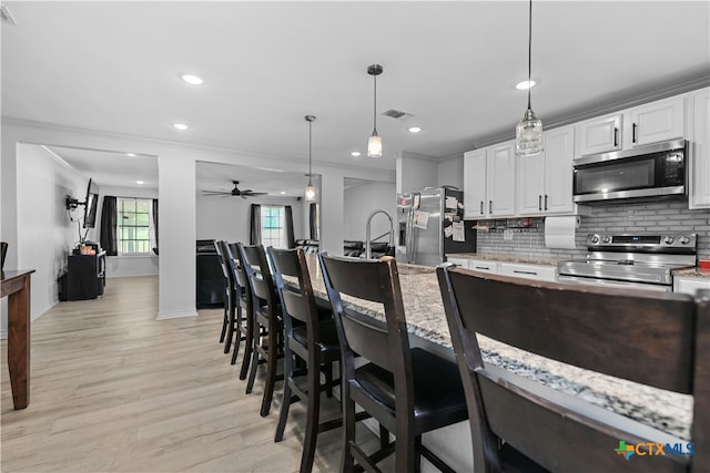 120 Mighty Oak Ln, Killeen, TX 76542 - kitchen with stainless steel appliances, tasteful backsplash, crown molding, light wood-type flooring, and baseboards