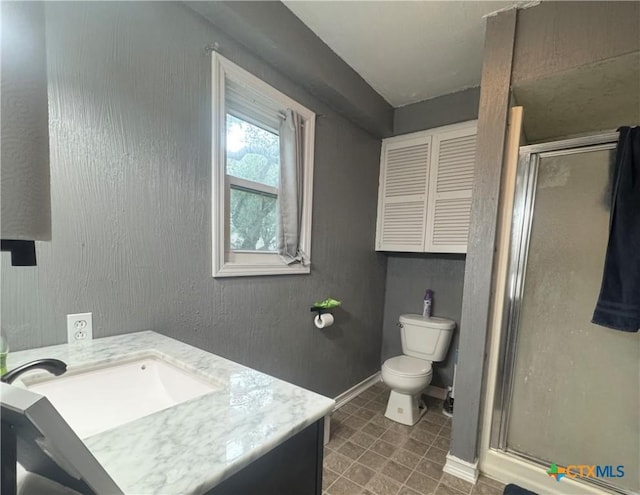 212 Whitfield St, Yoakum, TX 77995 - bathroom with a stall shower, toilet, vanity, and baseboards