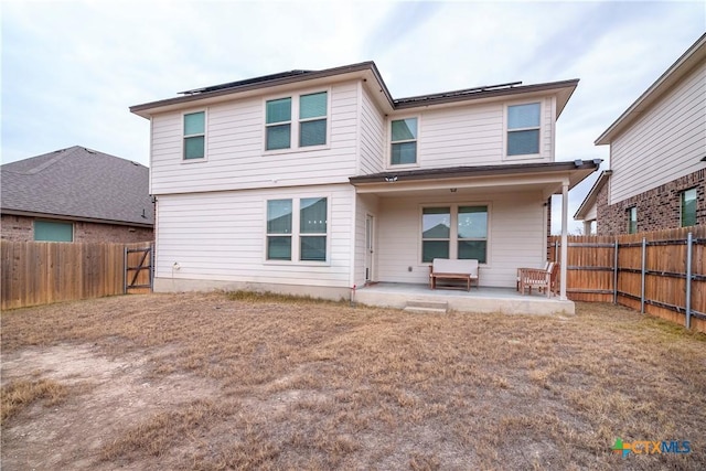 rear view of house with a patio and solar panels